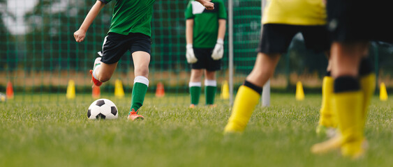 Kids playing football outdoors. Group of anonymous kids kicking a classic soccer ball. Football match at sports summer camp