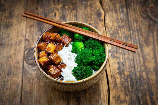 Bowl of coconut rice with tofu, broccoli and sesame seeds