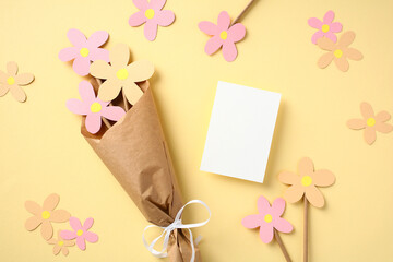 Happy Mothers Day concept. Bouquet of flowers made of colored cardboard, a children's craft and blank paper card mockup.