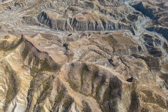 Drone view of rough rocky mountains with dry river in daylight