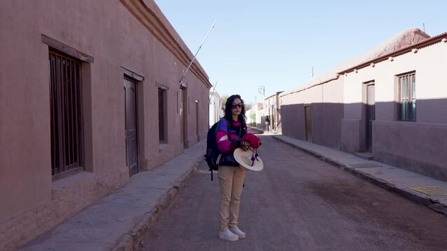 portrait latin woman backpacker with andean wool vest on the street of san pedro de atacama