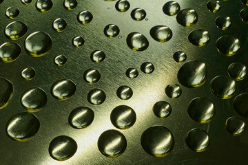 Makroaufnahme von Wassertropfen auf goldenem Metall