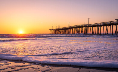 Venerable wood fishing pier in Virginia Beach at sunrise.