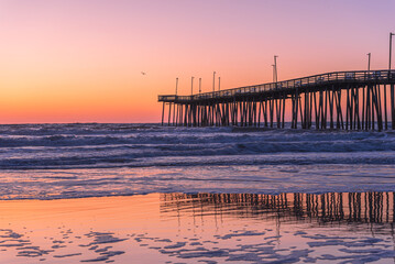 Fototapeta premium Venerable wood fishing pier in Virginia Beach at sunrise.