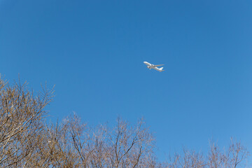 青い空の中を上昇する飛行機
