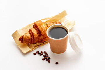 One paper cup of coffee with croissant. Takeaway coffee with snack