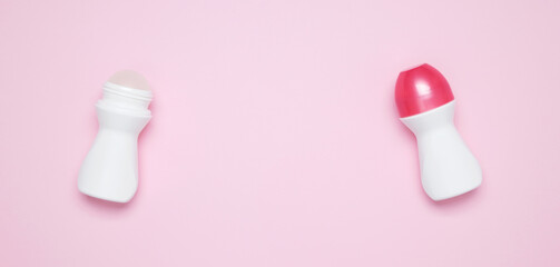 Cosmetic beauty products on pink background. Roll on deodorant branding mock up. Skin care and beauty concept. Top view, flat lay, copy space, banner