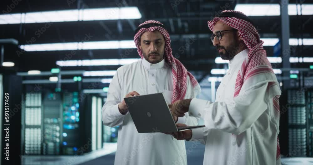 Aufkleber In the Modern Data Center: Middle Eastern AI Engineer and IT Specialist Working in Server Room, Talking, Doing System Maintenance Check with Laptop Computer. Specialists Implementing Database Updates