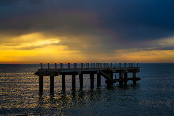 Naklejka na ściany i meble Pier on the sea at sunset