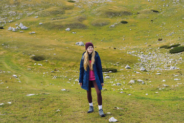 Active recreation in the mountains. A young woman goes uphill during a mountain hike