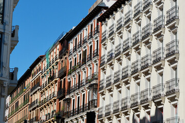 Fototapeta na wymiar Colourful line of classical vintage buildings with windows and balconies in the centre of Madrid, Spain
