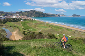 nice senior woman cycling with her electric mountain bike in the hills above Zarautz, Basque...