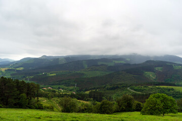 Fototapeta na wymiar Green hills covered with forest low clouds, Basque Country, Spain