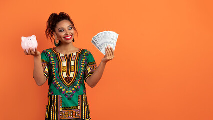 Positive black woman with piggy bank and dollar banknotes