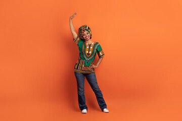 Positive black woman in african costume waving hello