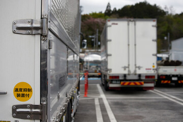 Naklejka premium 高速道路のサービスエリアの駐車場に並ぶ大型トラックの風景