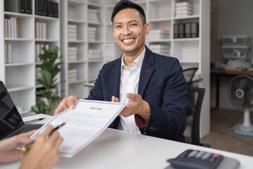 Close-up of a businessman shaking hands with a young Asian female, Work with document in the office.