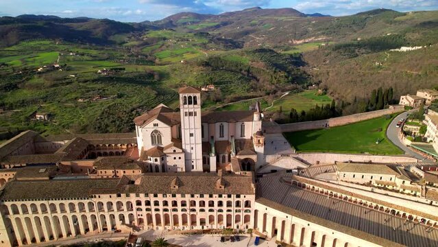 Assisi Italy Sacro Convento medieval arched gallery aerial drone view and town panoramic city skyline in Umbria at sunset historic architecture UNESCO world heritage site travel documentary film