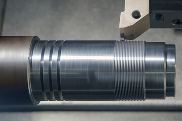 The CNC lathe machine thread cutting at the end of metal shaft  parts.