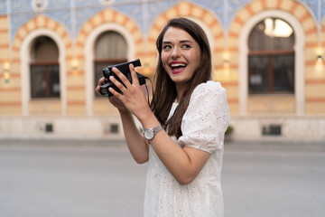 The young woman takes photos in the city