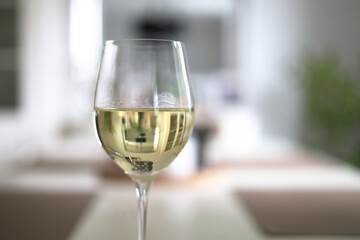 Kieliszek białego wina stojący na brzegu długiego stołu