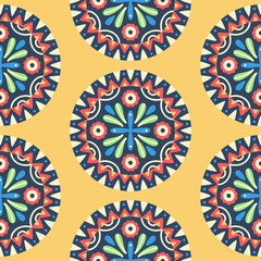 Seamless pattern with Mandala. Round symmetrical decorative ornament of abstract flowers, plants and geometric elements in the form of triangles. Mexican folk style. Yellow, red, blue colors. Vector