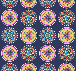 Seamless pattern with Mandala. Round symmetrical decorative ornament of abstract flowers, plants and geometric elements in the form of triangles on dark background. Mexican folk style. Vector