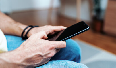 Smartphone with touch screen in male hands close-up.