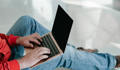 Fototapeta na wymiar Man holding laptop and typing on keyboard