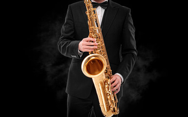 Saxophonist on a black background close-up.