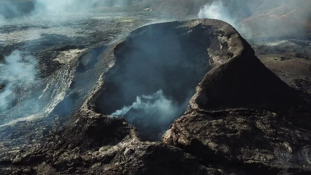 4K Aerial drone footage of Fagradalsfjall a slightly active volcano eruption in Geldingadalir, Reykjanes, Iceland. Cold Lava surrounded by smoke and dramatic sky. Iceland Volcanic eruption Grindavik.
