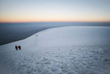 Climbers climbing Mount Ararat along the steep slope of the glacier in front of the summit, minimalist ascent of climbers