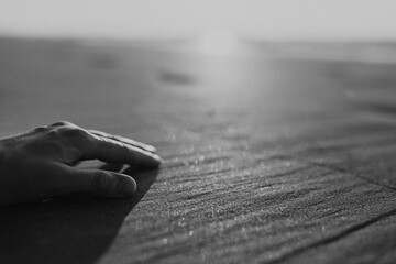 Close-up of a hand on the beach.