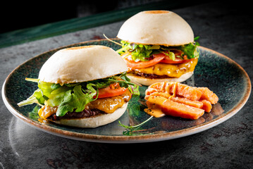 two Bao delicious chicken burger  with meat, cheese and vegetablea on plate