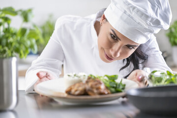 An experienced chef checks the finished food before the waiter takes it to the guest in the restaurant