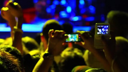 Fans among excited spectators record a rock concert by their mobiles. Tracking Video Camera
