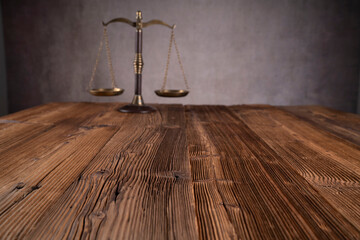 Law symbols composition. Gavel, scale and Themis sculpture on the rustic wooden desk. Gray...