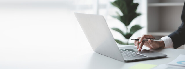 A business man working in a private room, He is typing on a laptop keyboard, He uses a messenger to chat with a partner. Concept of using technology in communication.