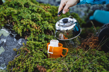 Tea party in nature, tourist food, coffee in the mountains, a hot drink for vivacity with caffeine, a metal kettle.