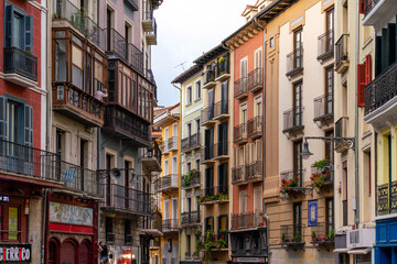 Fototapeta na wymiar PAMPLONA, SPAIN - JULY 04, 2022: Pamplona, Navarra, SPAIN. The beautiful streets of the city of Pamplona. Beautifully coloured buildings with flowers of different colours, hanging from the balconies.