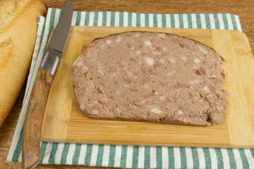 tranche de pâté de campagne, en gros plan, sur une planche à découper