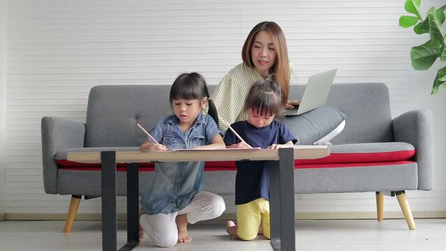A single mother working from home is tired, busy, and has to teach her two mischievous daughters homework. Family concept. head of working family