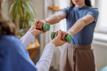 Teenage girl doing exercise with a nurse.