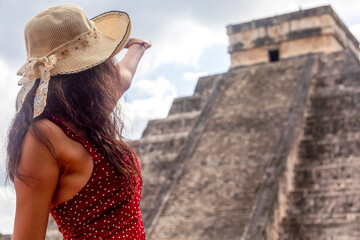 Sexy tourist inviting to the pyramid of Chichen Itza in the Yucatan Peninsula, a very visited...