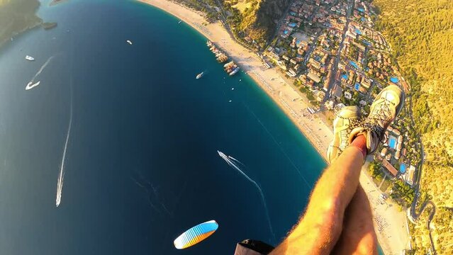 paragliding point of view in Oludeniz. legs paraglider flying over the sea on sunset. Extreme and active types of recreation. panoramic aerial view down from gopro. High quality FullHD footage