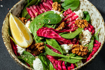 Vegetable salad of beet, baby spinach, nuts and cheese. Food recipe background. Close up