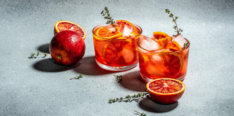 refreshing alcoholic cocktail with Sicilian red oranges, Aperitif on a light background. Long banner format. top view