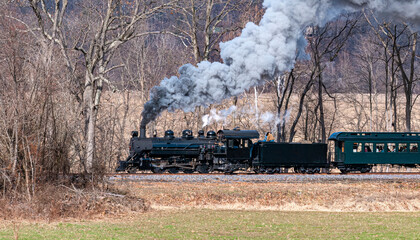 View of a Narrow Gauge Restored Steam Passenger Train Blowing Smoke and Traveling Thru Farmlands on...