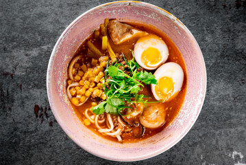Asian noodle soup, ramen with chicken, tofu, vegetables and egg in bowl