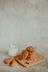 Oatmeal cookies with milk on light background with crumbs